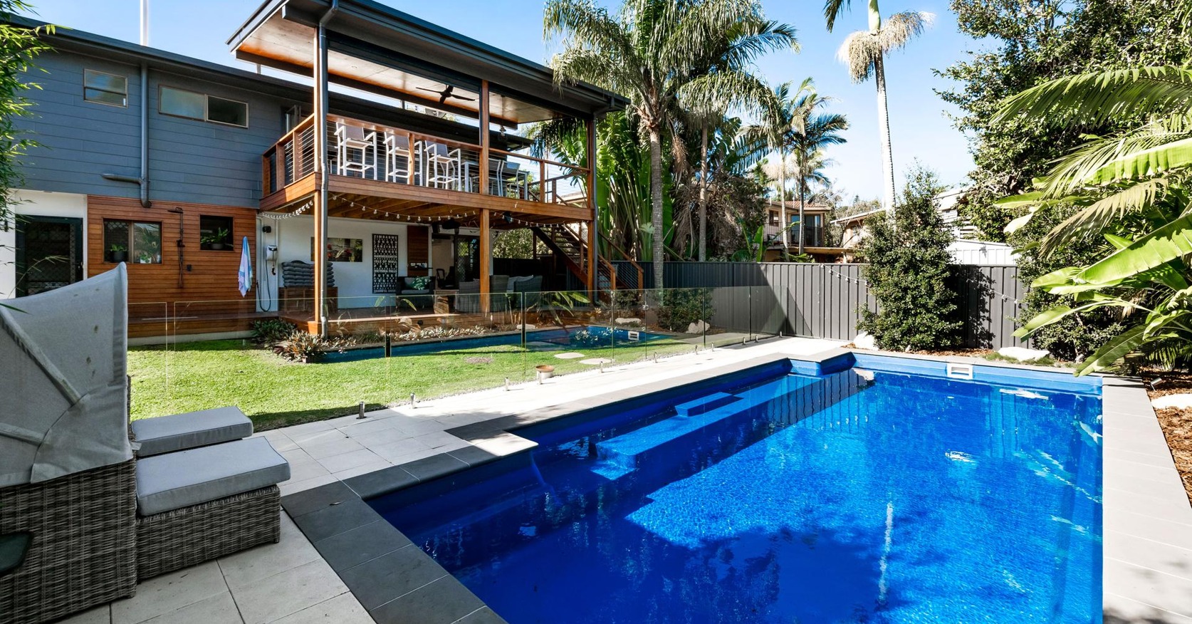Renovated rear of the home with covered upper deck, sheltered under-deck living and a new pool