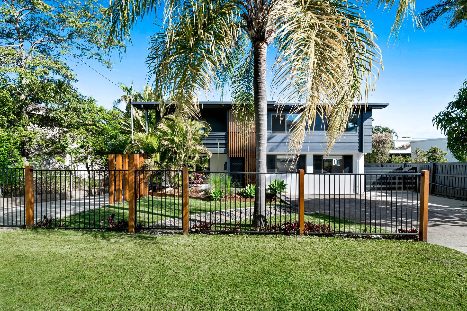 Renovated street frontage with darker cladding, timber screening and new landscaping