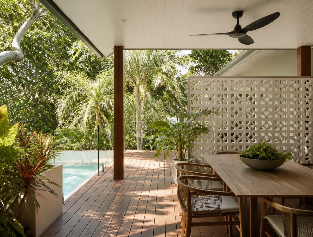 Coastal home opening from the dining area to a covered deck